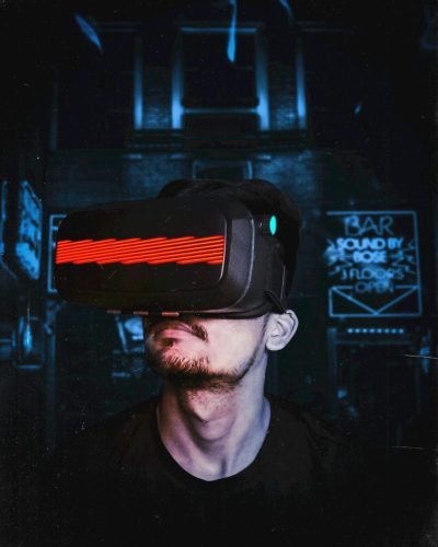 Young man immersed in a virtual reality experience using a VR headset, showcasing futuristic tech in a gaming environment.