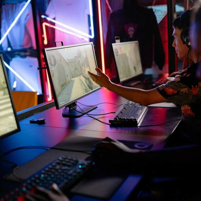 Two gamers engage in a competitive match in a neon-lit gaming space.